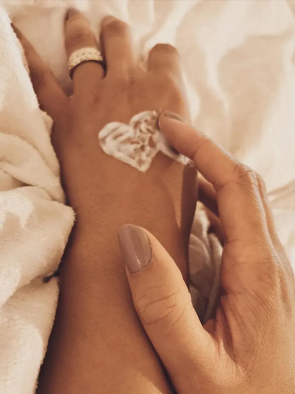 Body lotion in the shape of a heart on the back of a hand.